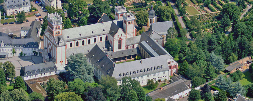 Um den Altbau gruppieren sich Gästehaus, Verwaltung mit Bibliothek, Wirtschaftsgebäude und Werkstätten. Links unten ist ein Teil des "Schammatdorfes" zu erkennen, auf der Nordseite der Kirche liegen der Friedhof und die Gebäude der Pfarrei St. Matthias.